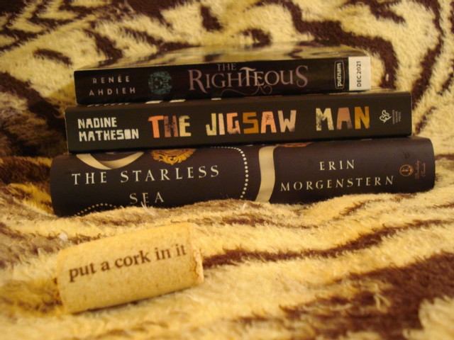 A stack of books with a cork in front on an animal print blanket
